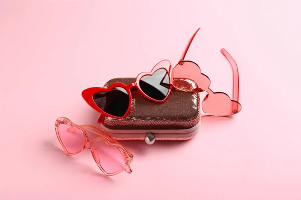 色の背景にスタイリッシュなハート形のサングラスと財布 — ストック写真