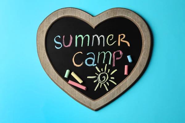 Herzförmige Tafel mit Text Sommerlager, Zeichnung und Kreidestäbchen auf farbigem Hintergrund, Draufsicht — Stockfoto