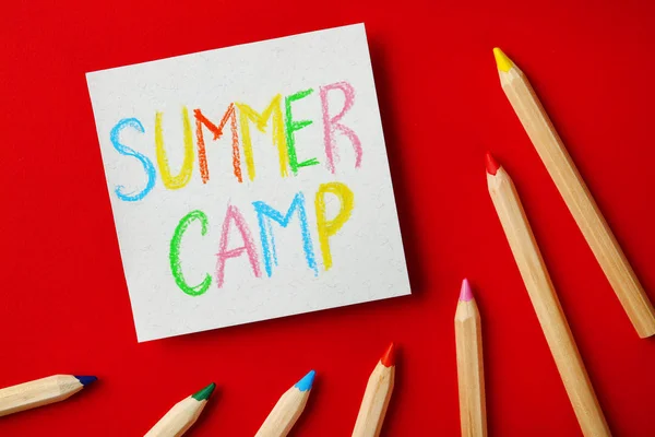 Papel com texto escrito SUMMER CAMP e diferentes lápis sobre fundo de cor, flat lay — Fotografia de Stock