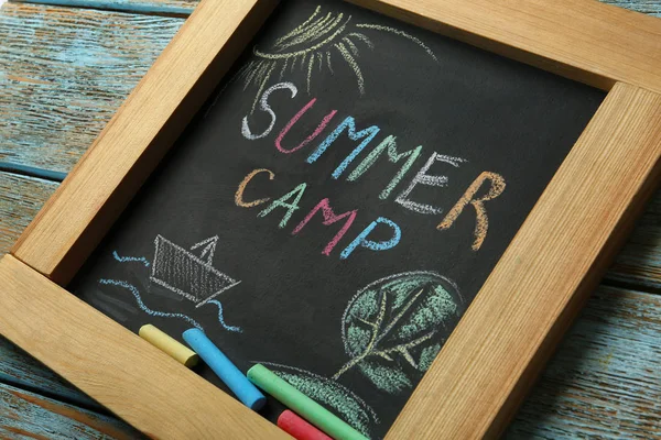 Tafel mit Text-Sommerlager, Zeichnungen und Kreidestäbchen auf Holzgrund, Nahaufnahme — Stockfoto