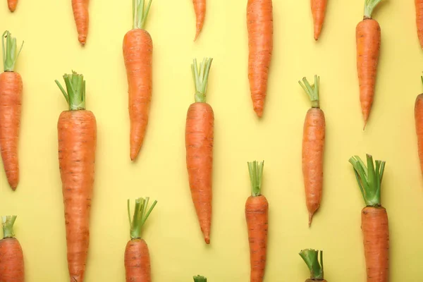 Composizione di posa piatta con carote fresche su sfondo di colore — Foto Stock