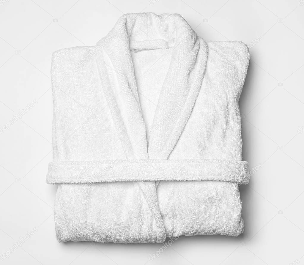Clean folded bathrobe on white background, top view