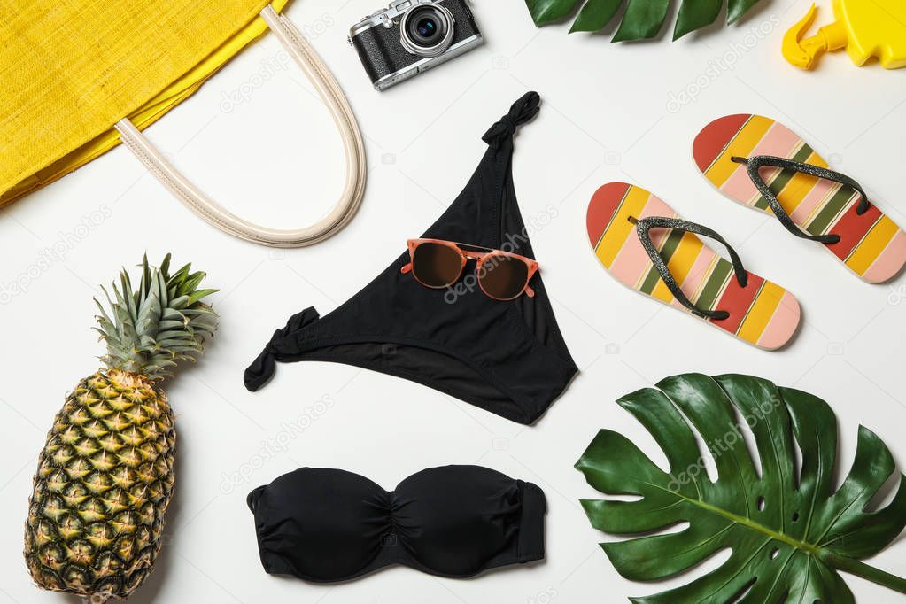 Flat lay composition with swimsuit and beach accessories on white background