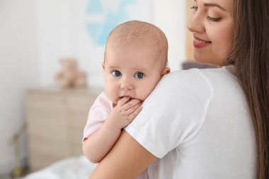 Anne sevimli bebeğini evde tutuyor. Metin için alan
