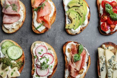 Gri arka plan üzerinde farklı lezzetli bruschettas, düz yatıyordu