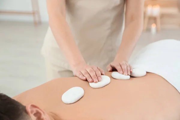 Man receiving hot stone massage in spa salon, closeup — Stock Photo, Image