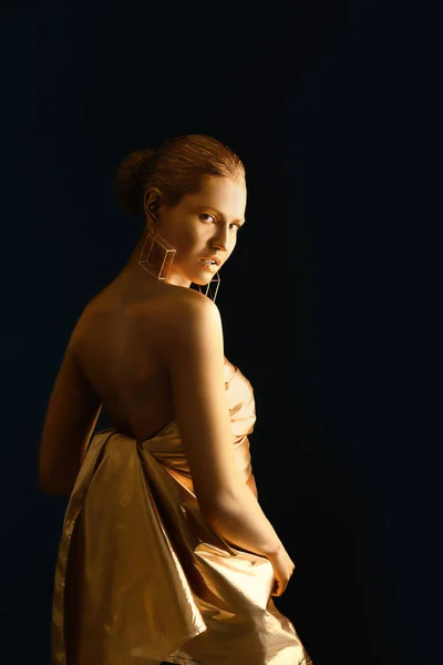 Porträtt av vacker dam med guldfärg på huden mot svart bakgrund — Stockfoto