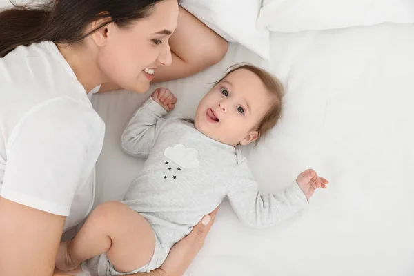 Niedliches Baby mit Mutter auf dem Bett liegend, oben Blick — Stockfoto