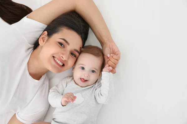 Ritratto di madre con il suo bambino carino sdraiato sul letto, vista dall'alto. Spazio per testo — Foto Stock