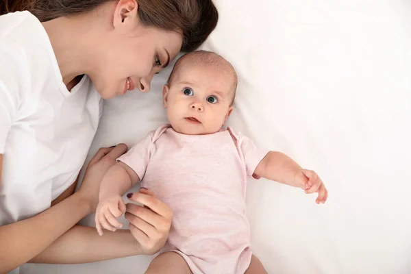 Porträt der Mutter mit ihrem niedlichen Baby im Bett, von oben — Stockfoto