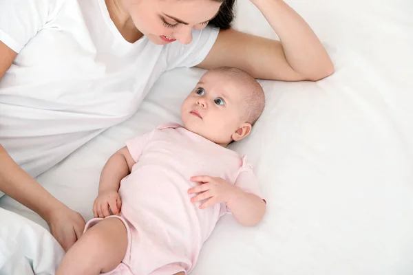 Niedliches Baby mit Mutter auf dem Bett liegend, über der Ansicht. Raum für Text — Stockfoto