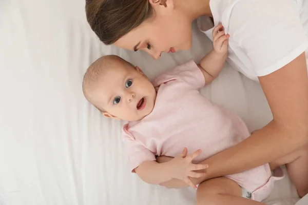 Retrato de mãe com seu bebê bonito deitado na cama, vista superior — Fotografia de Stock