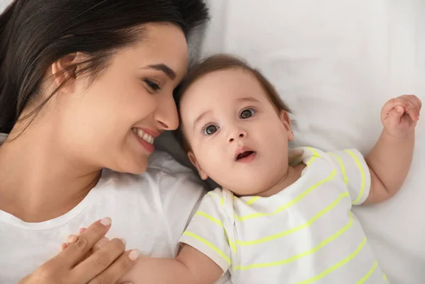 Portret van moeder met haar schattige baby liggend op bed, bovenaanzicht — Stockfoto
