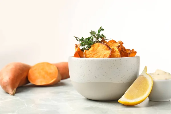 Tigela de batatas fritas doces com molho e limão na mesa contra o fundo branco. Espaço para texto — Fotografia de Stock