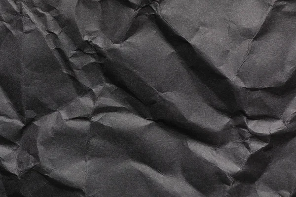 Arkusz czarnego papieru zmięty jako tło. Przestrzeń do projektowania — Zdjęcie stockowe