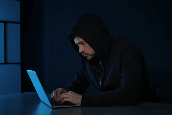 Человек использует ноутбук в темной комнате. Уголовное преступление — стоковое фото