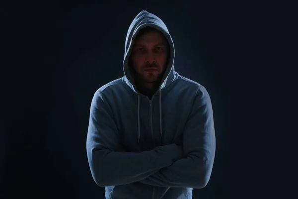Hombre misterioso con capucha sobre fondo oscuro. Peligroso criminal — Foto de Stock