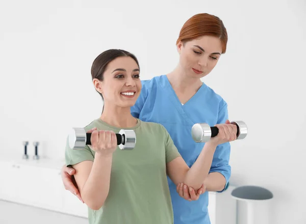 Professional physiotherapist working with female patient in rehabilitation center — Stock Photo, Image