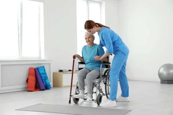 Profesjonalny fizjoterapeuta pracujący z pacjentem w podeszłym wieku w centrum rehabilitacji — Zdjęcie stockowe