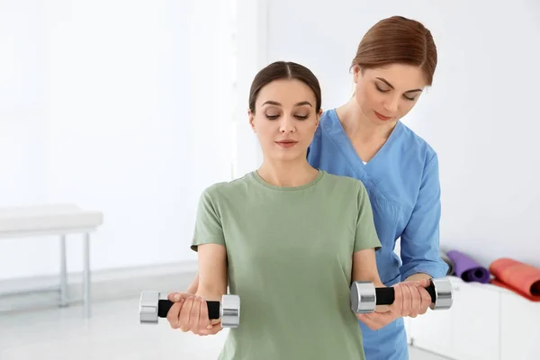 Professional physiotherapist working with female patient in rehabilitation center — Stock Photo, Image