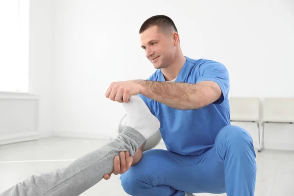 Professionelle Physiotherapeutin arbeitet mit männlichen Patienten im Rehabilitationszentrum — Stockfoto