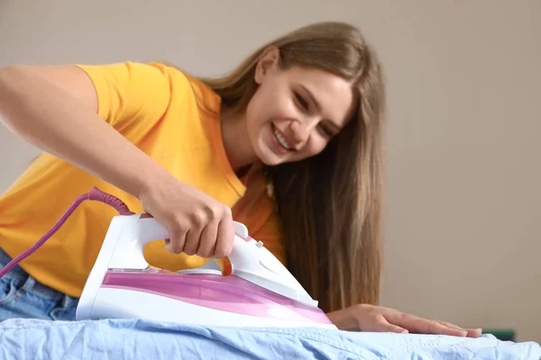 Junge Frau bügelt zu Hause Hemd an Bord — Stockfoto