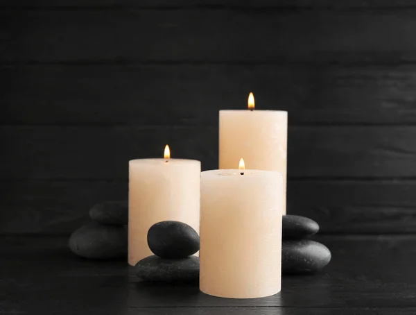 Brennende Kerzen und Wellness-Steine auf dem Tisch. Raum für Text — Stockfoto