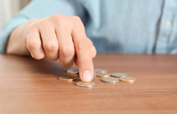 Man counting coins at table, focus on hand — Stock Photo, Image