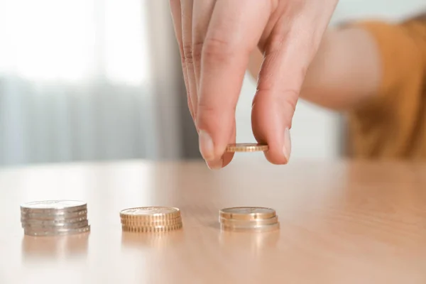 Woman stacking coins at table, focus on hand. Space for text — Stock Photo, Image