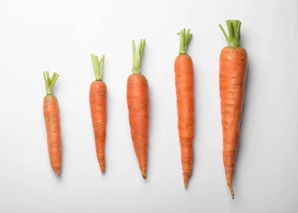 Плоска композиція зі свіжою морквою на кольоровому фоні — стокове фото