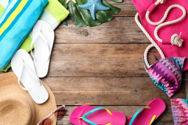 Ahşap arka plan üzerinde mayo ve plaj aksesuarları ile düz yatıyordu kompozisyon. Metin için alan