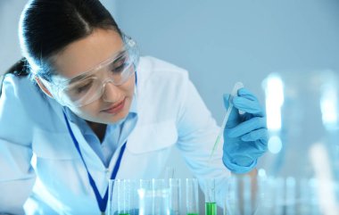 Modern kimya laboratuvarında numune ile çalışan kadın bilim adamı