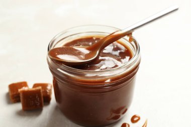Lezzetli karamel sos ve açık renkli kaşık kavanoz