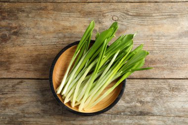 Ahşap masa üzerinde yabani sarımsak veya ramson ile Plaka, üst görünümü