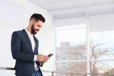 Yakışıklı genç adam ışık odasında telefon kullanıyor. Çalışma süresi