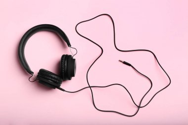 Stylish headphones on color background, top view clipart