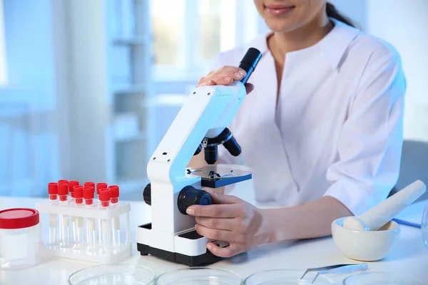 Ženský vědec s mikroskopem v chemické laboratoři, zaostřená — Stock fotografie