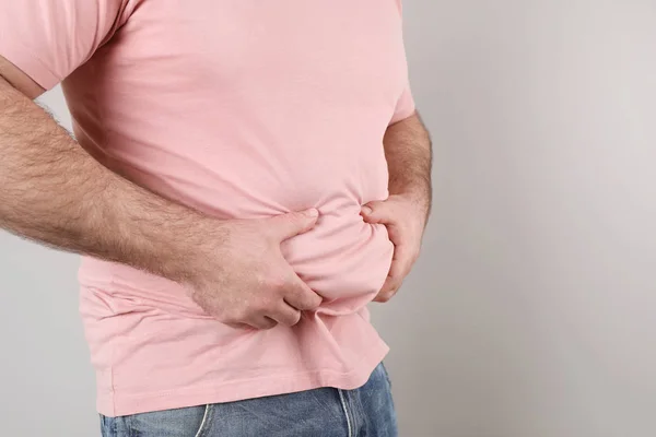 Homem com excesso de peso com grande barriga no fundo de cor, close-up. Espaço para texto — Fotografia de Stock