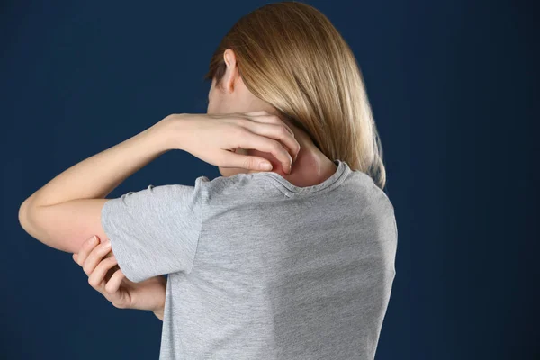 Mujer rascándose el cuello sobre fondo de color. Síntoma de alergia — Foto de Stock