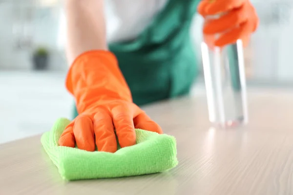 Trabajador en guantes limpiando mesa con trapo, primer plano. Espacio para texto — Foto de Stock