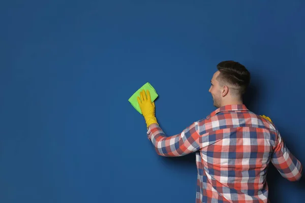 Чоловік чистить кольорову стіну ганчіркою. Простір для тексту — стокове фото