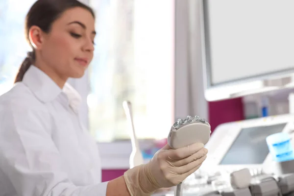 Sonógrafo sosteniendo sonda de ultrasonido con gel en la clínica — Foto de Stock