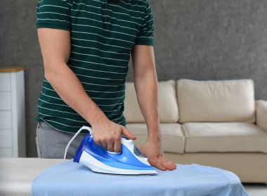 Adam evde tahta Gömlek Ütü, closeup. Metin alanı