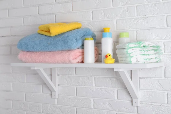 Plank met baby accessoires op witte bakstenen muur — Stockfoto