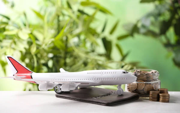 Modelo de avião, passaporte e moedas na mesa contra fundo desfocado. Espaço para texto — Fotografia de Stock