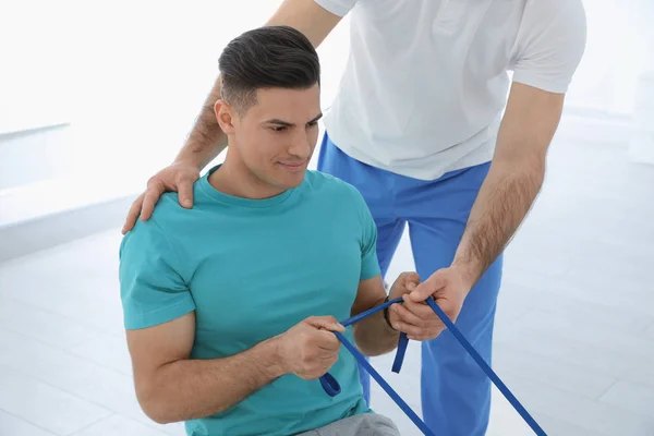 Professionele fysiotherapeut werken met mannelijke patiënt in revalidatiecentrum — Stockfoto