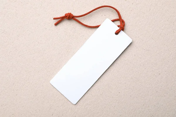 Cardboard tag with space for text on color fabric, top view