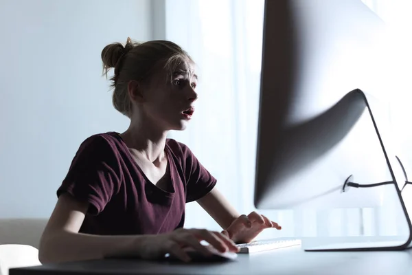 Menina adolescente chocado usando computador na mesa dentro de casa. Perigo da internet — Fotografia de Stock