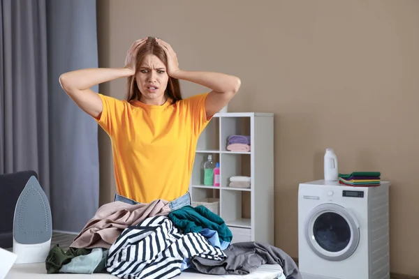 Emotionale Frau an Bord mit Bügeleisen und Kleiderstapel im Badezimmer. Raum für Text — Stockfoto