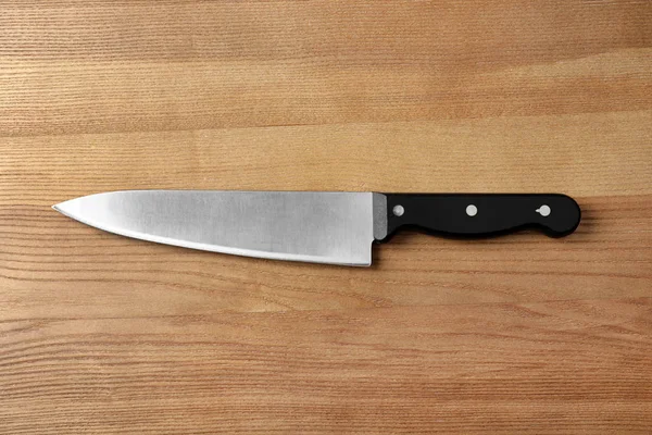 Cuchillo de chef afilado sobre fondo de madera, vista superior — Foto de Stock